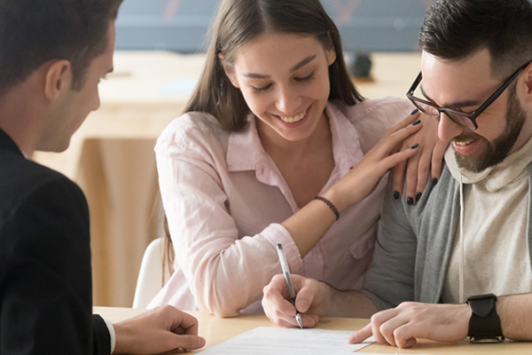 man and woman signing a contract